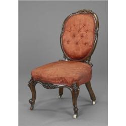 A Victorian walnut rococo revival nursing chair, the shaped oval back, serpentine apron and scrol...