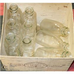 9 VINTAGE GLASS MILK BOTTLES IN A  WOODEN ALCB
