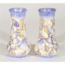 Pair of hand painted Clews Chameleonware vases, decorated with blue and brown flowers onto a white g