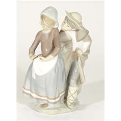 Hand painted Lladro figure group of a young boy kissing a girl, marks to base, 25cm high