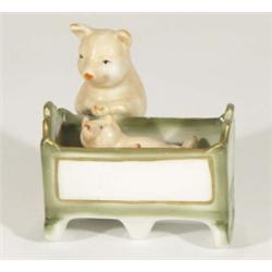 Hand painted porcelain mother pig rocking a piglet in a crib, 10cm high