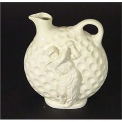 White glazed ceramic golf ball design ewer, relief moulded with a golfer, 22cm high