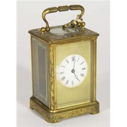 Victorian brass carriage clock with cut glass panels, chased with swags with enamel dial, 17cm high