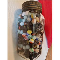 big jar of rare marbles in blue ribbon coffee jar