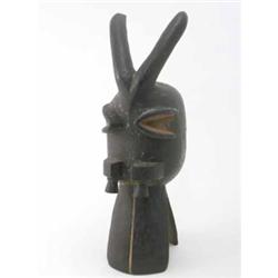 A Baule carved wood helmet mask, Ivory Coast, modelled as an animal head with open mouth and prot...