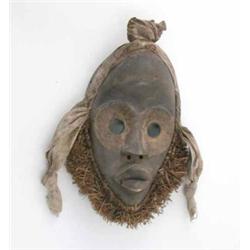 An early 20th century Dan Male carved wood mask, Ivory Coast, with raffia and cloth decoration, 1...