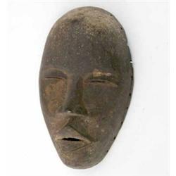 A Dan female carved wood mask, Ivory Coast, with slit eyes and open mouth, 11.25 ins...