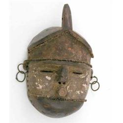 A Bambyue carved wood mask, Zaire, with iron nail decoration, 9 ins...