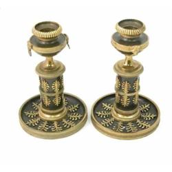 A pair of Regency brass candlesticks, on bronzed column stems, with urn shaped scones and gilt le...