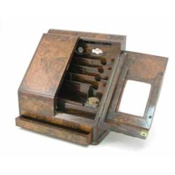 A late 19th century burr-walnut stationary box with grained sides, the two doors enclosing a comp...