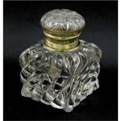 An Edwardian pressed glass inkwell, of wrythen square shape with hinged, star cut cover and brass...