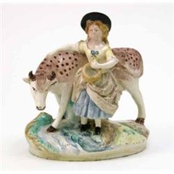 A mid-19th century earthenware milkmaid and cow group, milkmaid with bucket, standing beside cow,...