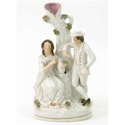 A Victorian Staffordshire figure group, male and seated female companion beside tree-stem, on ova...