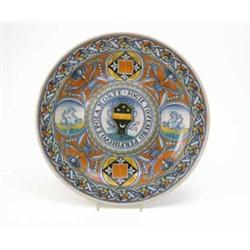An Italian majolica armorial charger, painted with coat of arms on the raised central boss, anima...