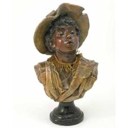 A painted composition bust of a boy, negro character wearing hat and loose-fitting jacket, on bla...