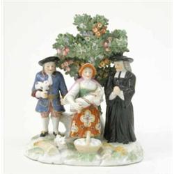 A 19th century continental porcelain "Tithe Pig" group, cleric and young family beneath fruiting...
