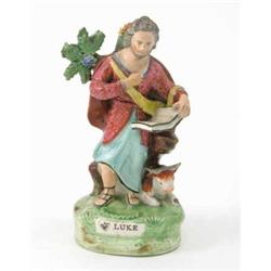An early 19th century Staffordshire pottery figure, "St. Luke", standing with book, calf lying be...