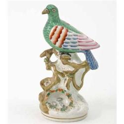 A Victorian Staffordshire pottery model of a bird, painted in bright colours, perched upon branch...
