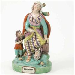 An early 19th century Staffordshire pottery figure, "Widow", seated lady with child beside, on ti...