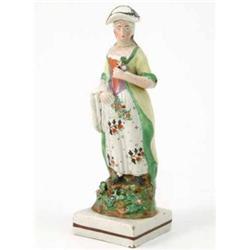 A late 18th century Staffordshire figure of a female gardener, in long floral dress, on square ba...