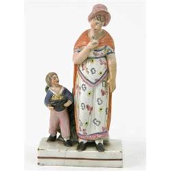 An early 19th century Staffordshire figure group, mother wearing red cloak, child holding hat con...