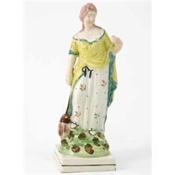 A late 18th century Staffordshire pottery figure representing The Lost Piece Found, female holdin...