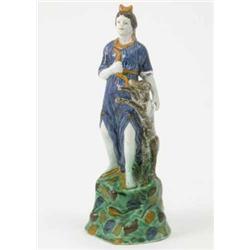 A late 18th century prattware figure of Diana, in long blue dress, holding bow, dog beside, on ra...