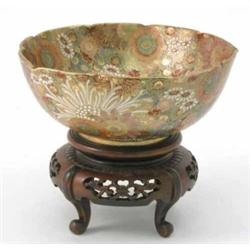 A Satsuma bowl with dense floral decoration, 7.5ins and hardwood stand....