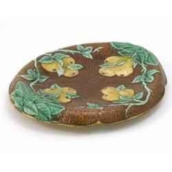 A 19th century majolica stand, oval and moulded with pears and leaves against a brown ground, riv...