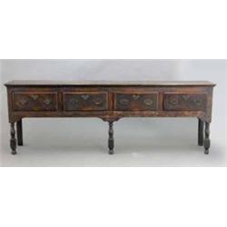 A George III oak dresser base, with four drawers fitted brass loop handles (some missing), with p...