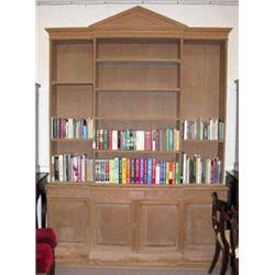 A 20th century pine veneer breakfront library bookcase, with architectural pediment and three ope...