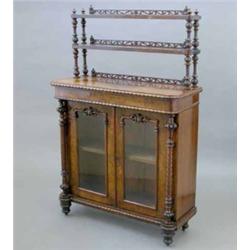 A Victorian walnut chiffonier, with double open shelf back over two glazed doors flanked by spira...