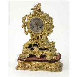 A 19th century French ormolu mantel clock, with rococo scroll case and silvered Roman dial, 11ins...