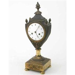 An early 19th century French bronze and ormolu mantel clock, in urn shaped case with enamelled Ro...