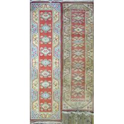 Two modern Turkish milas runners, each woven with salmon pink fields decorated with lozenges with...