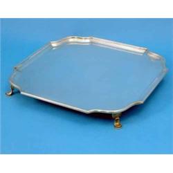 A George V square silver salver, with a moulded border and shaped corners on pad feet, maker Hawk...
