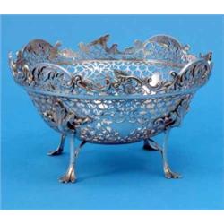 An Edwardian pierced silver fruit basket, with foliate neo-rococo decoration on four scroll feet,...