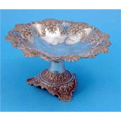 An Edwardian silver comport, decorated with a border of pierced cartouches between repousse flora...