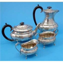 A George VI four piece silver tea set, of facetted oval form comprising tea and hot water pots, c...
