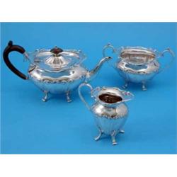A George V three piece silver tea set, each with shaped rims and foliate moulded decoration on sc...