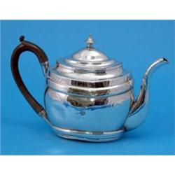A George III silver teapot, of stepped oval form, with engraved foliate decoration and wooden scr...