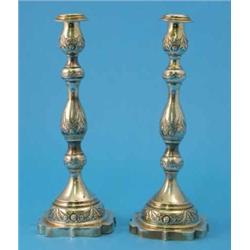 A pair of George V cast silver candlesticks, with multi-baluster stems and decorated with moulded...