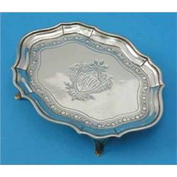 A George III silver teapot stand, of serpentine form with engraved decoration on four splayed leg...