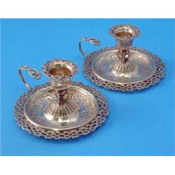 A pair Victorian silver chambersticks, with pierced rims and loop handles, each sconce supported...