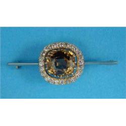 A zircon and diamond cluster brooch, mounted on a knife-edge bar, the cushion shape zircon within...