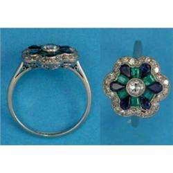 A platinum flowerhead cluster ring, millegrain-set with a central diamond bordered by 6 pear-shap...