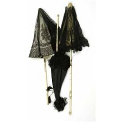 A Victorian black chantilly lace and ivory silk parasol, having ivory handle carved with a clappe...