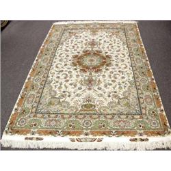 A fine Persian silk and wool carpet. Signed....