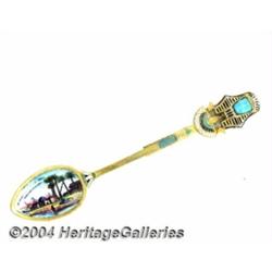 A SILVER-GILT AND ENAMEL MUMMY MASK SOUVENIR SPOON