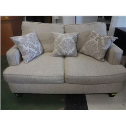 Beige loveseat with pillows